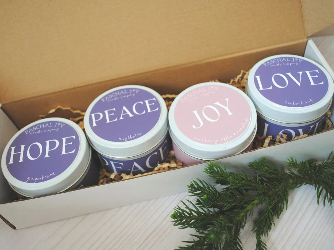 Four candles in a box with 'Hope', 'Peace', 'Joy', and 'Love' text on their lids.