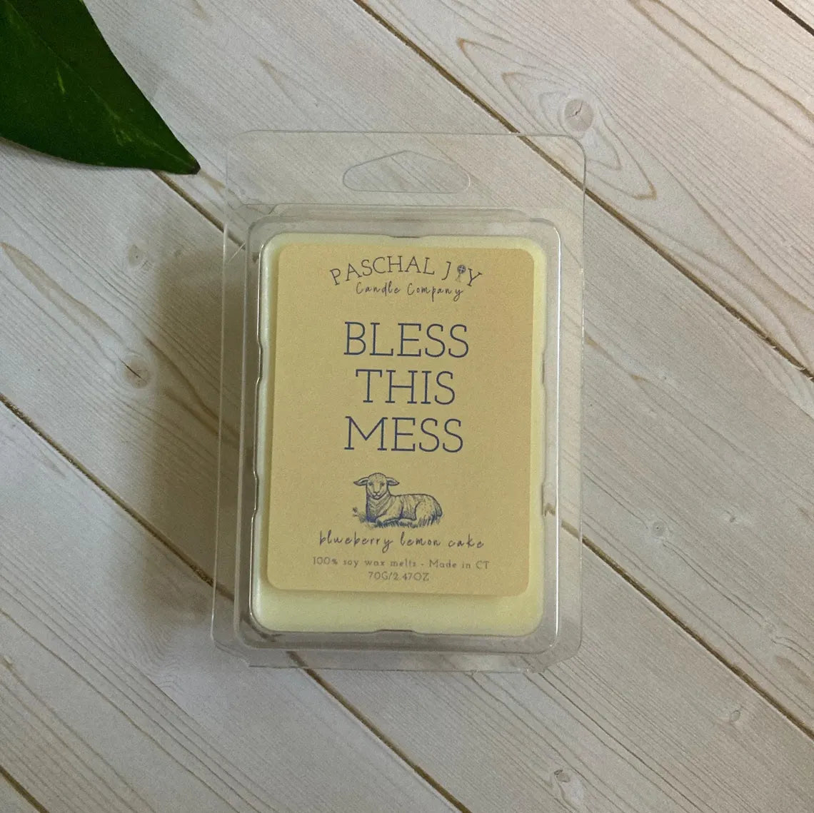 Wax melt in a clear container with 'Paschal Joy Candle Company' branding on a wooden surface.