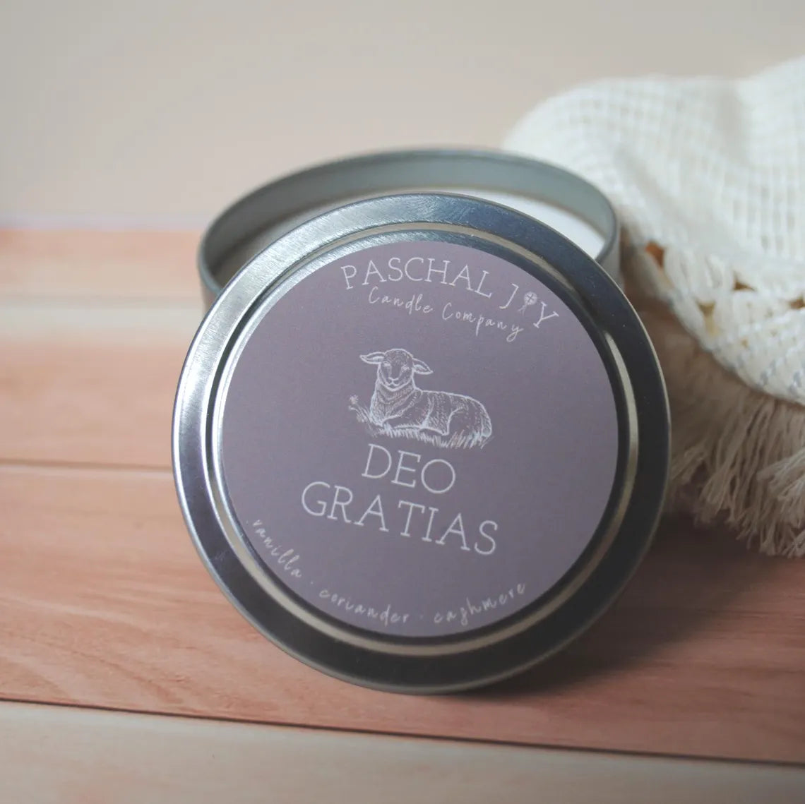 Deo Gratias Catholic Candle. Small brown tin on wood background