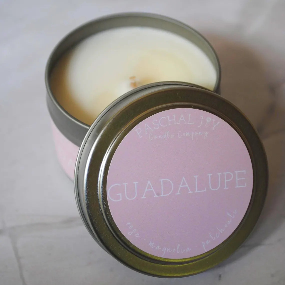 A small candle tin with a pink GUADALUPE label