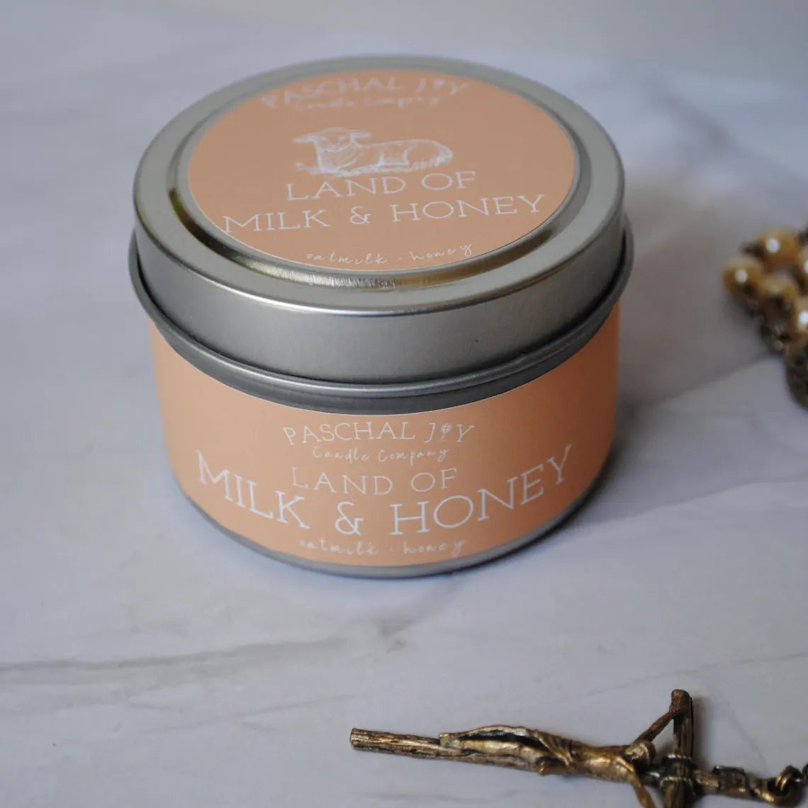 Land of Milk and Honey with Rosary on a grey background