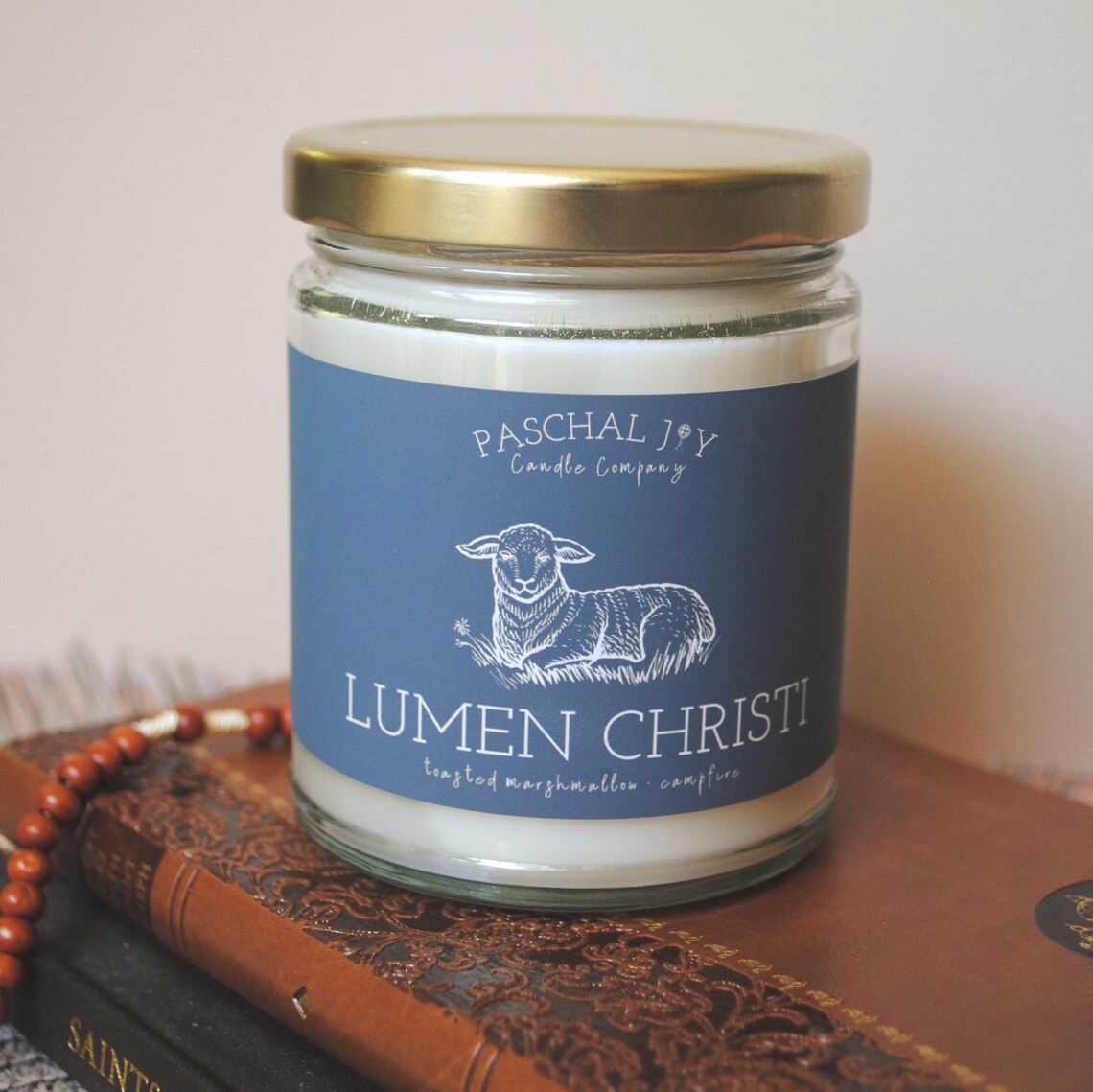 Candle jar grey label featuring a sheep illustration on a wooden surface.