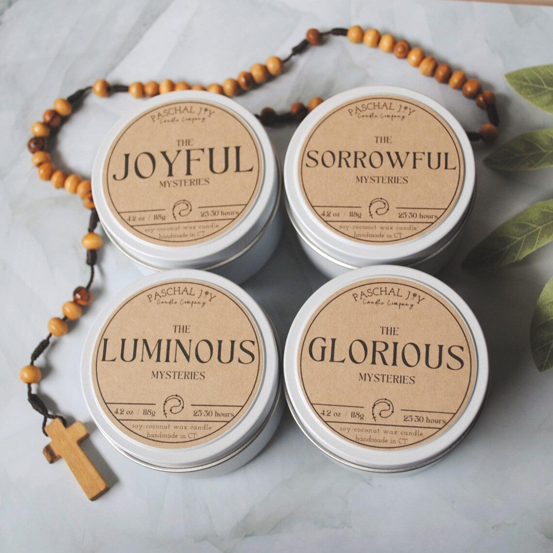 Rosary Candle Collection - white tins with a rosary on a grey background