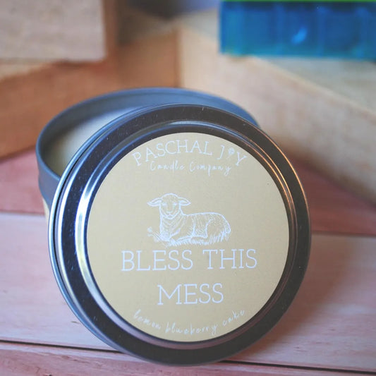 Bless This Mess Candle Tin on a wood background with toys and blocks