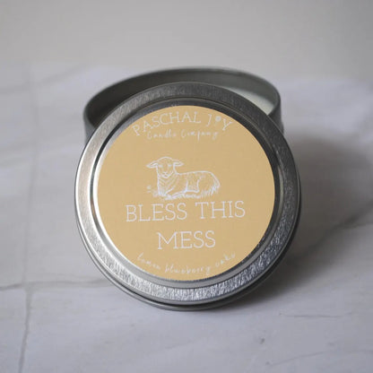 Front lid view of BLESS THIS MESS candle tin on grey background