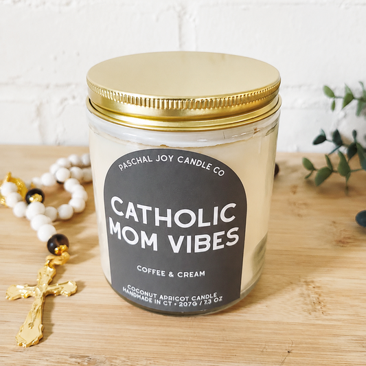 Brown label CATHOLIC MOM VIBES, Coffee and cream. Wooden colored ground with white and gold rosary