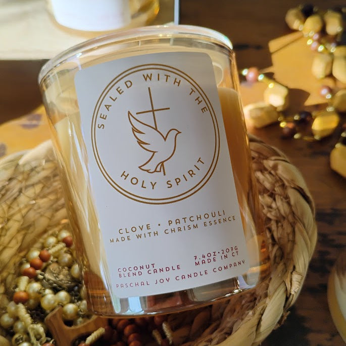 Catholic Chrism candle in basket with rosaries