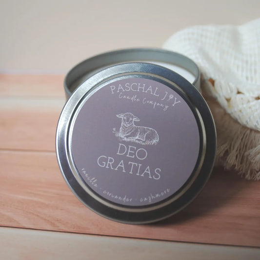 Deo Gratias Catholic Candle. Small brown tin on wood background