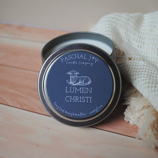 Candle tin with 'Paschal Joy Candle Company' label on a wooden surface