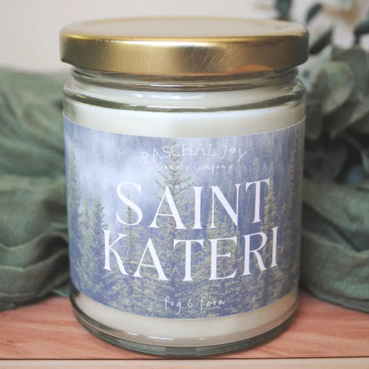 Saint Kateri candle on wood background with green cloth and leaves