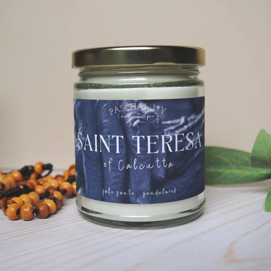 Black candle with a rosary and leaf in background