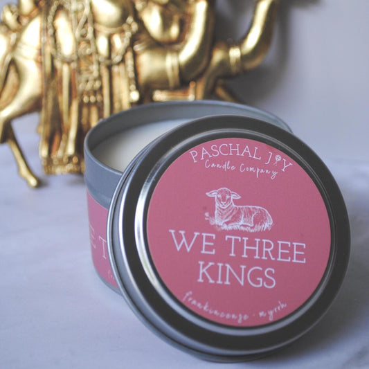 Candle tin labeled 'We Three Kings' with a gold nativity scene in the background