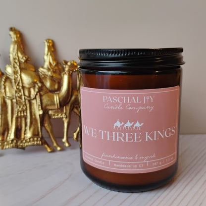 Amber Candle with We Three Kings Label and Gold statue in background